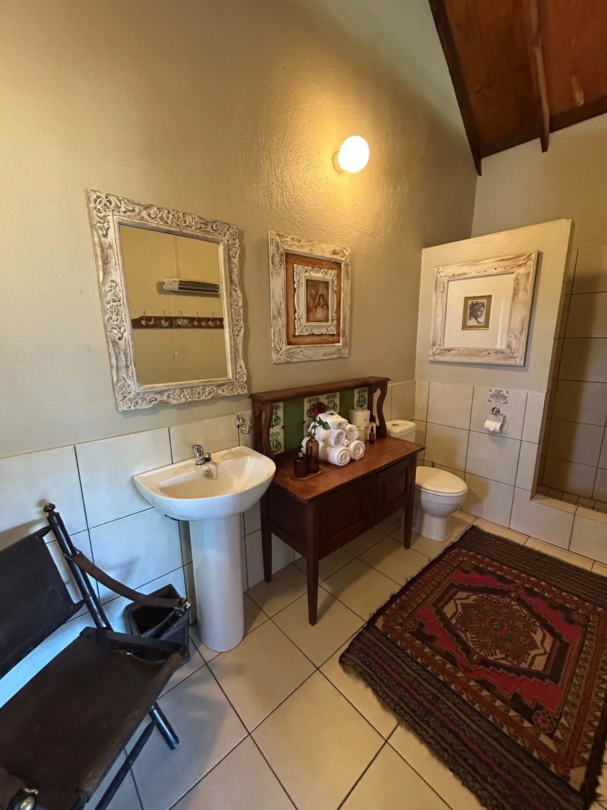 Bathroom basin, silver framed mirror and wooden cabinet
