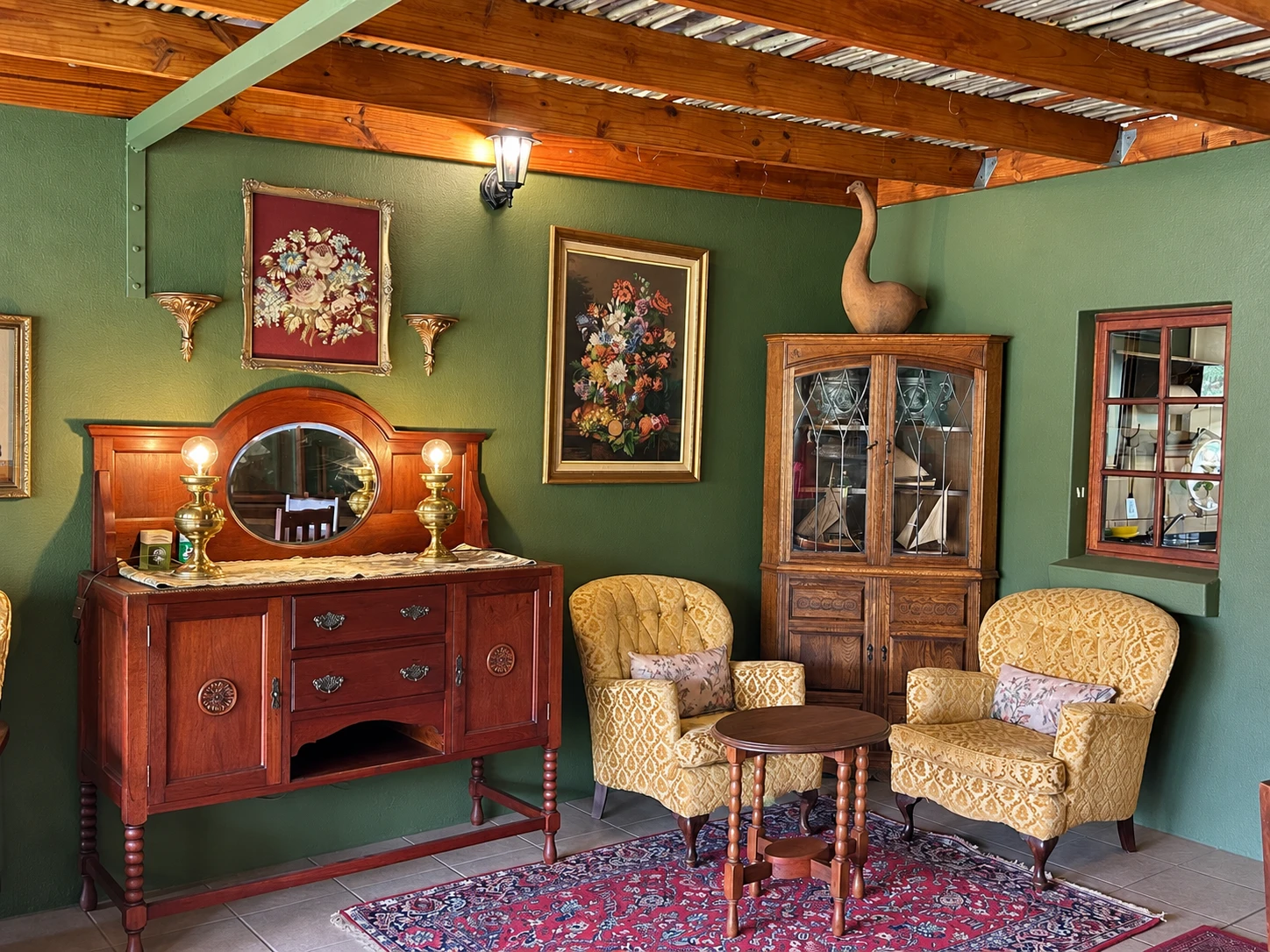 Gold armchairs, antique sideboard and floral artwork in the communal lounge