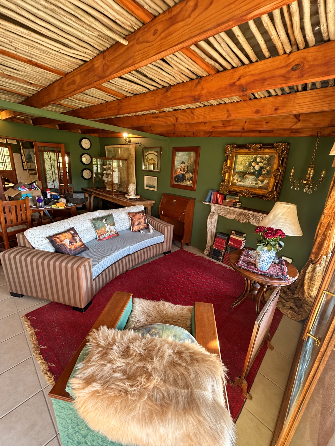Communal lounge sofa, armchair and decorative mantel beneath timber beams