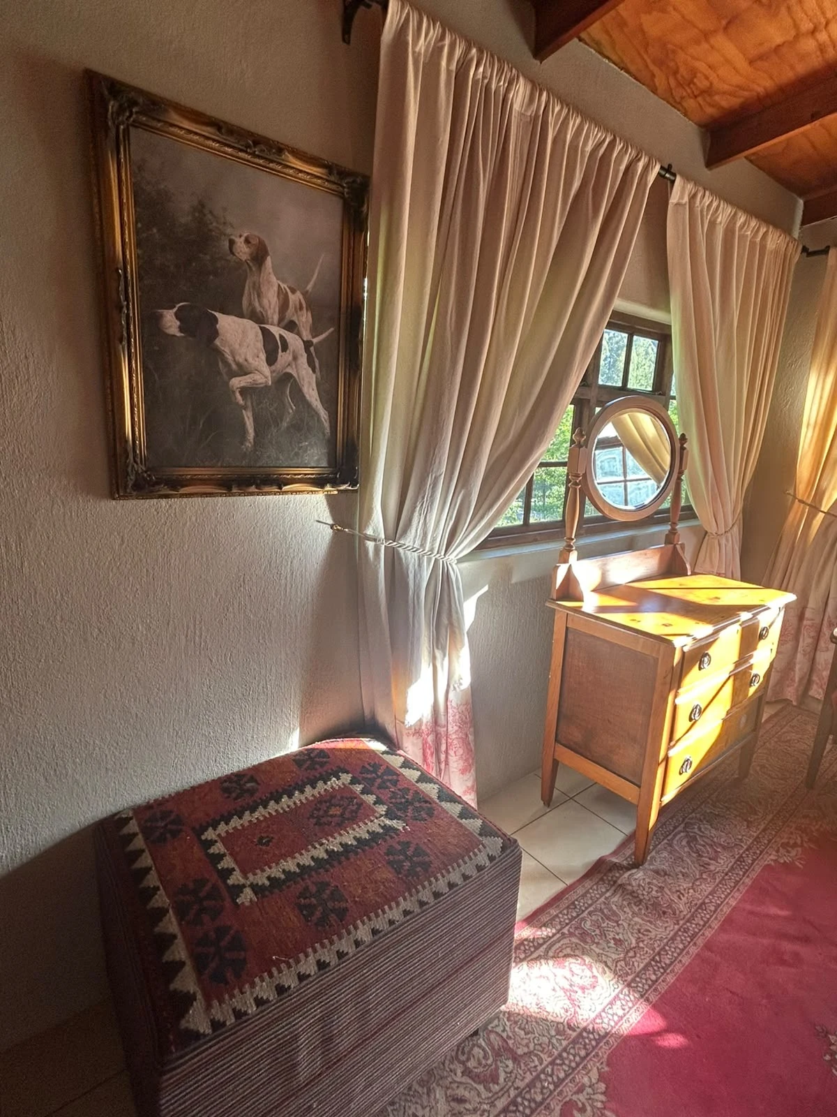 Curtained window, dressing table and artwork in the heritage room